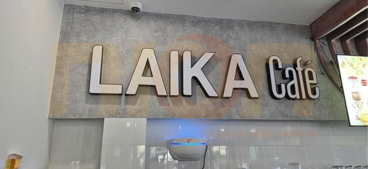 Đèn Nion C5-18 đang hoạt động trên tường ốp gạch dưới bảng hiệu Laika Cafe